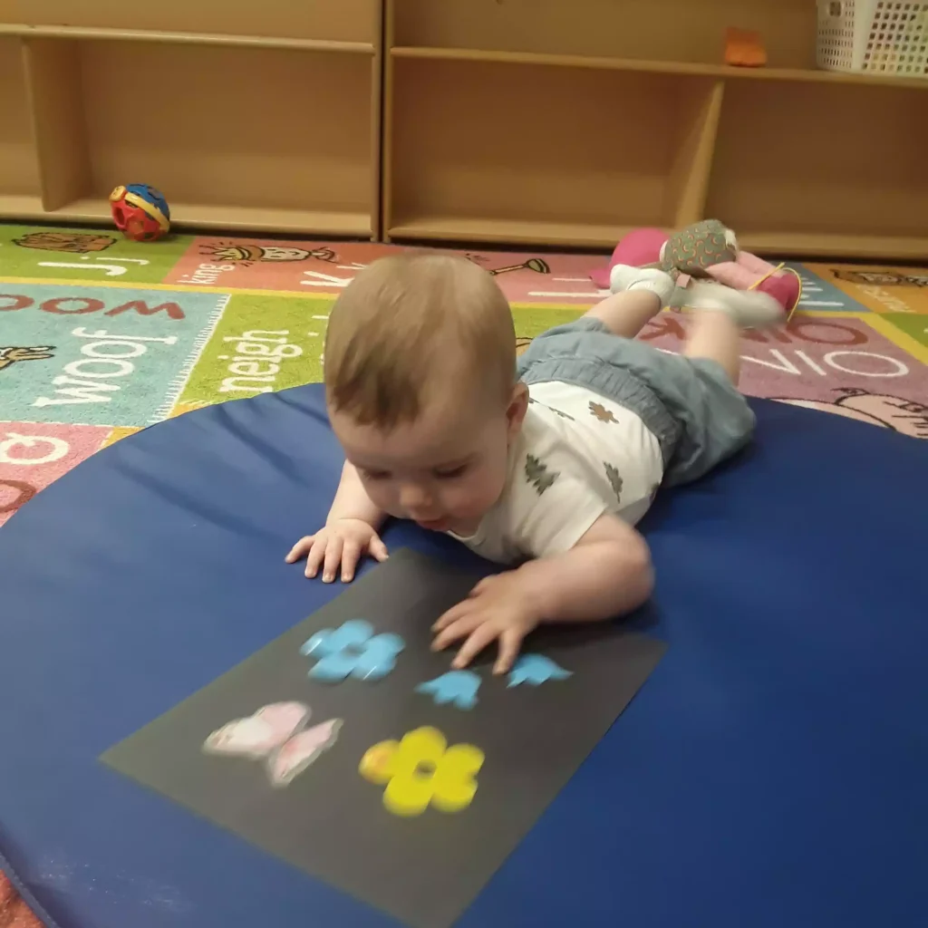 Infant during tummy time sensory activity in daycare classroom