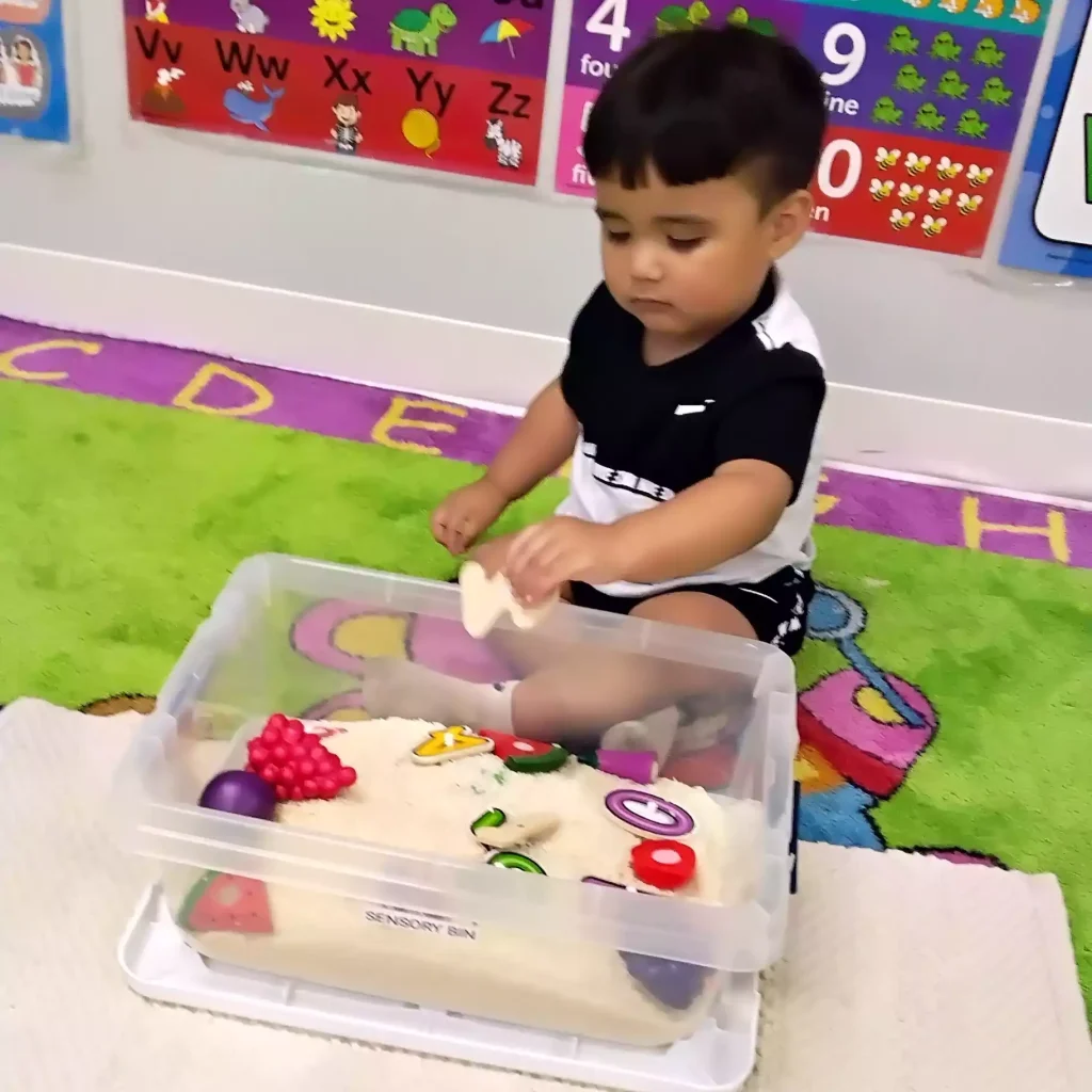 Child playing with sensory bin at Pinebrook Montessori