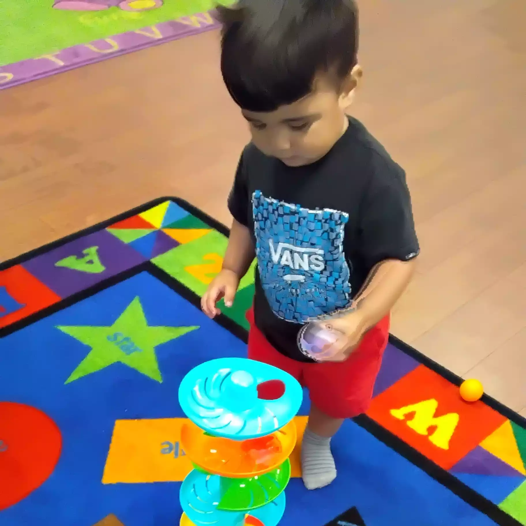 Pinebrook Pre-K Student Playing with Ball Drop Tower Activity Child playing with spiral ball tower at Pinebrook Montessori