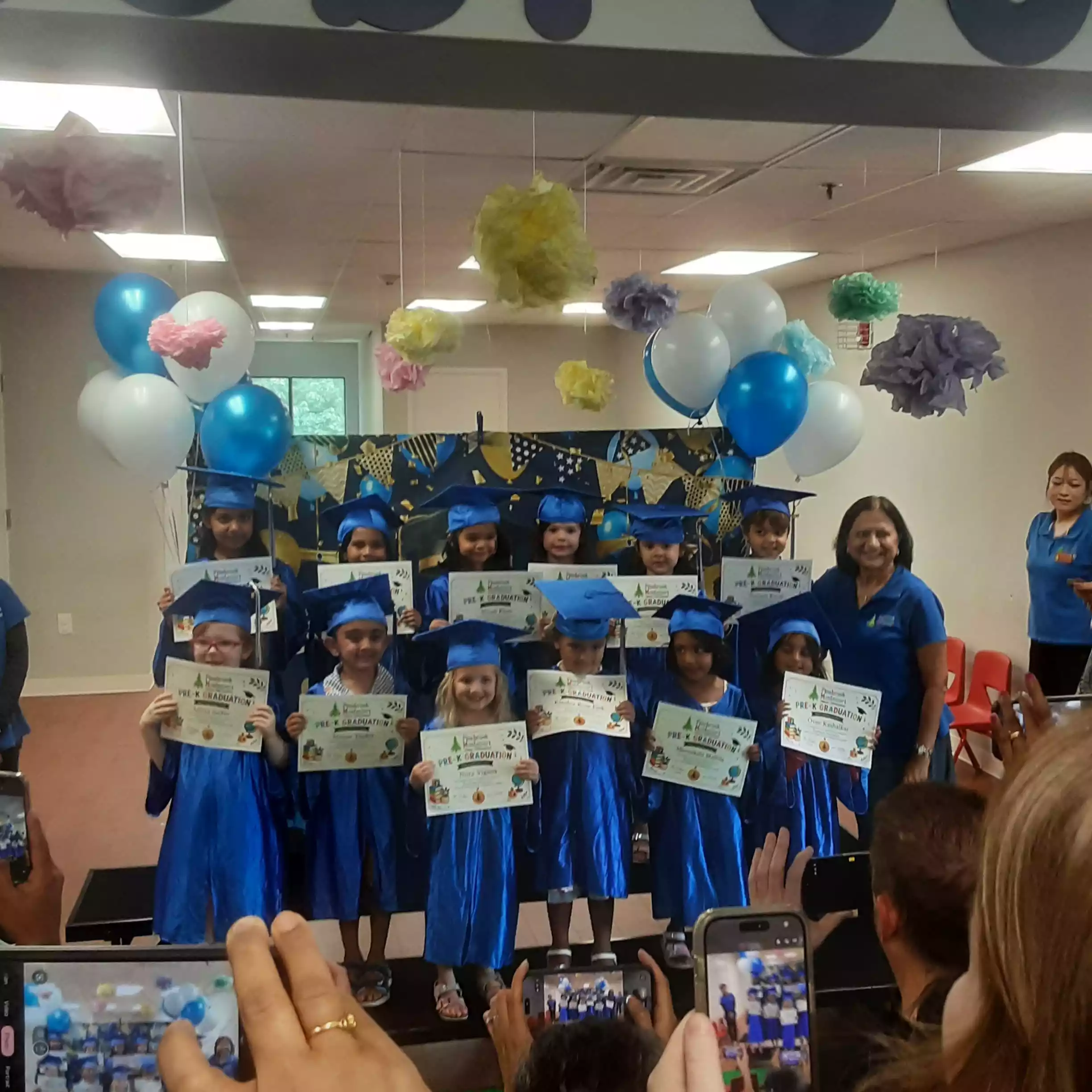 Audience Photographing Pinebrook Graduation Class Audience holding smartphones to photograph pre-K graduation group