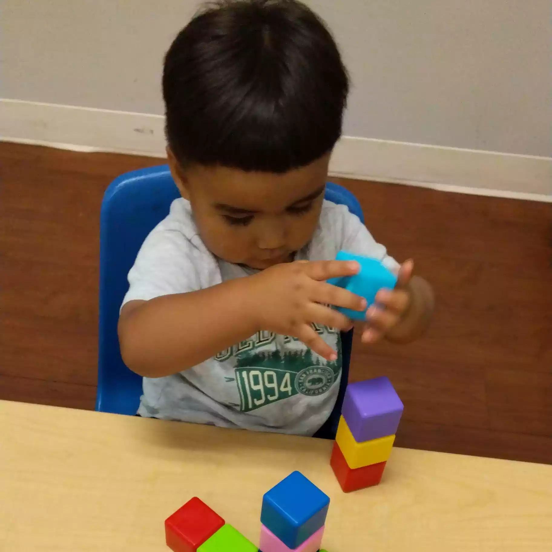 Pinebrook Pre-K Student Stacking Colorful Blocks Pinebrook Montessori student stacking colorful toy blocks