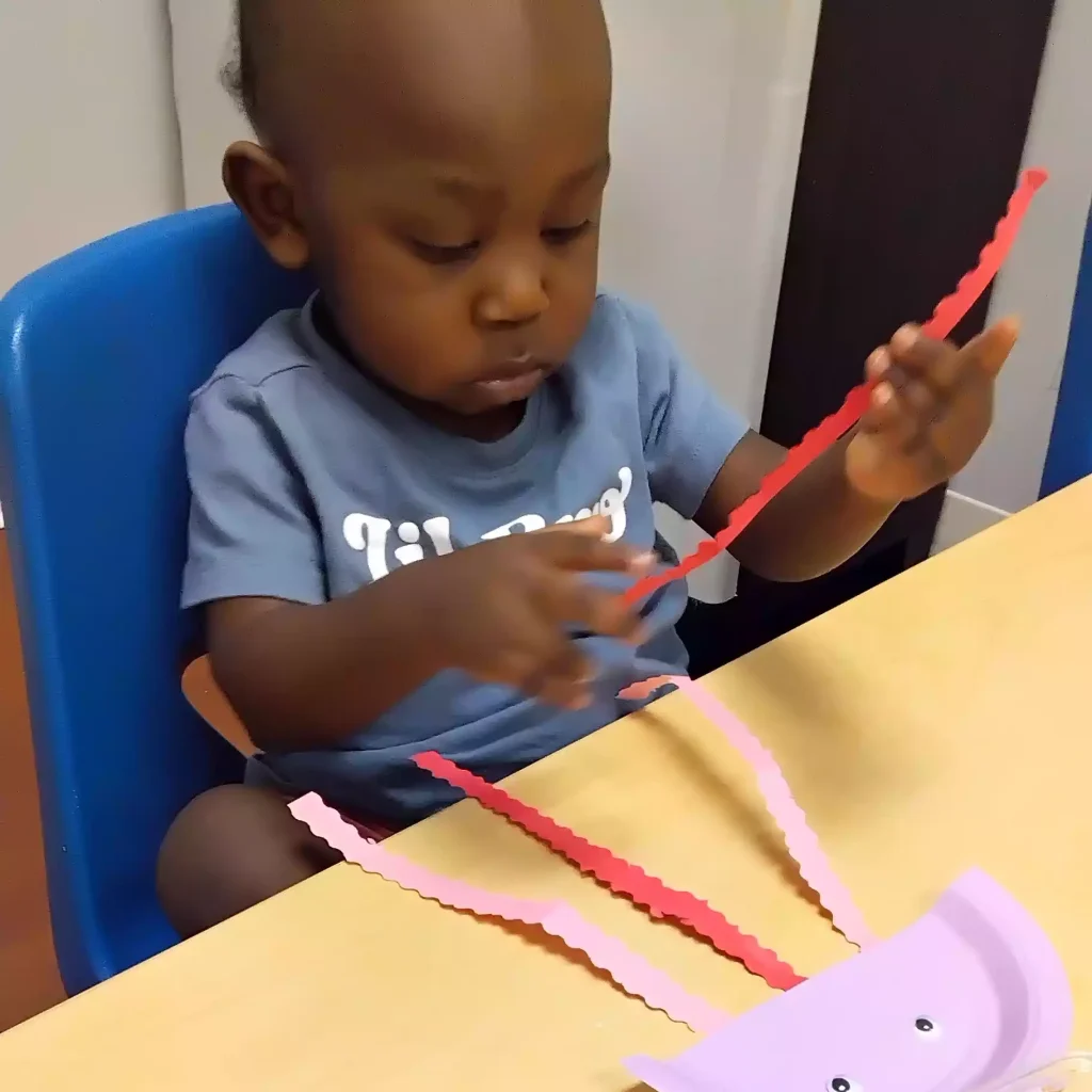 Toddler making jellyfish craft at Pinebrook Montessori