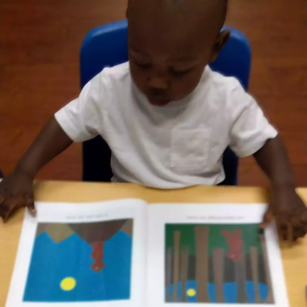 Child reading picture book at Pinebrook Montessori